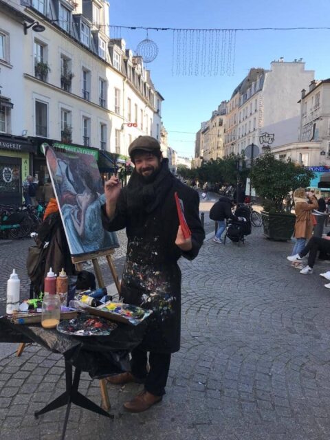 Artist painting on a street in Paris.