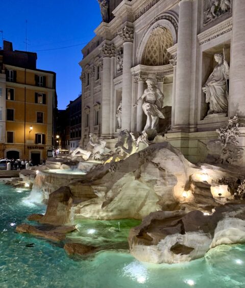 Fountain in Rome is lit at night.