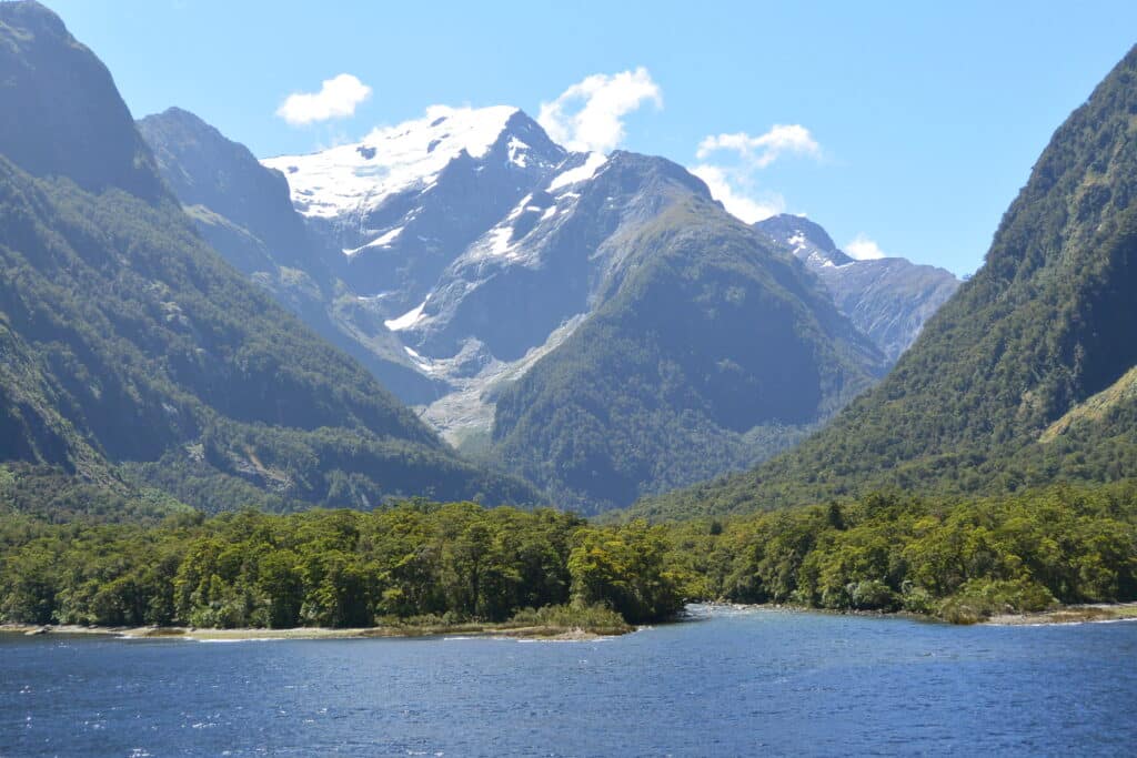 Snow peaked mountains lead down to glacier fed inlets with azure waters.
