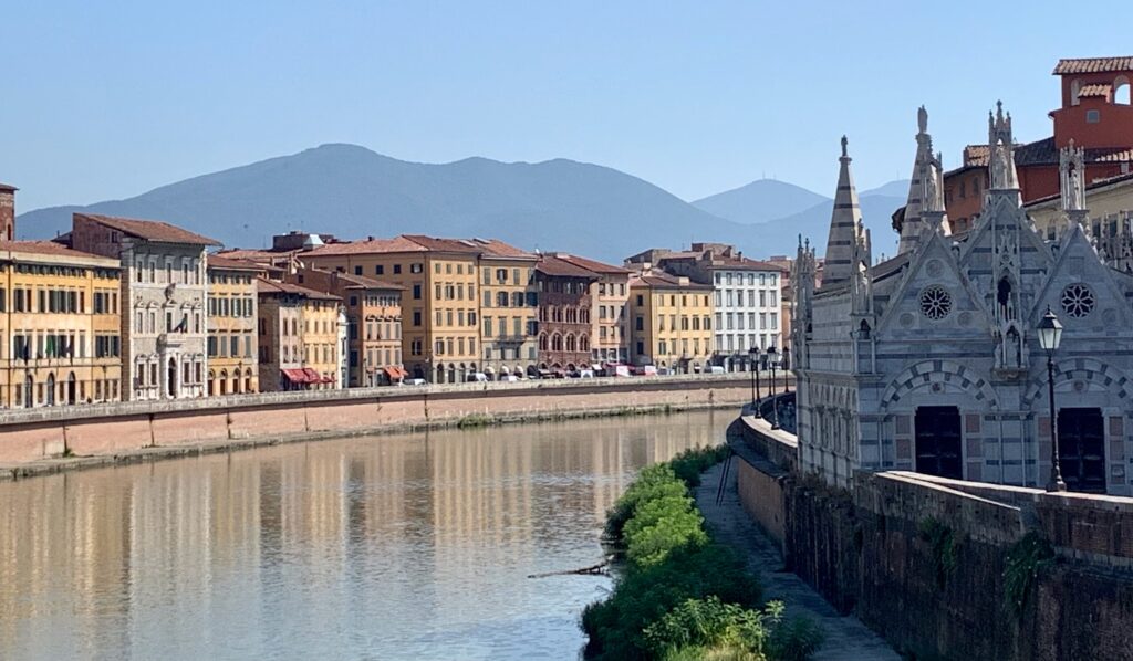 Florence Italy sits on a river and this photograph is of the river with buildings in brown with roof tiles in orange and brown.