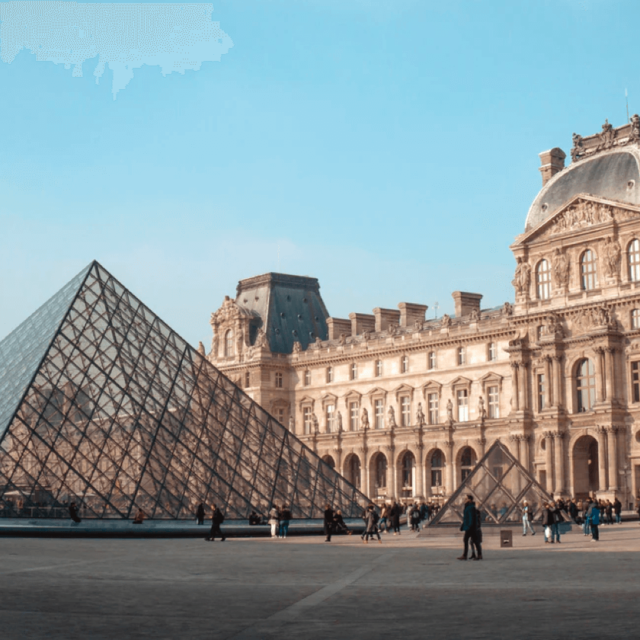 The main courtyard with the glass pyramid entrance to the Louvre Museum