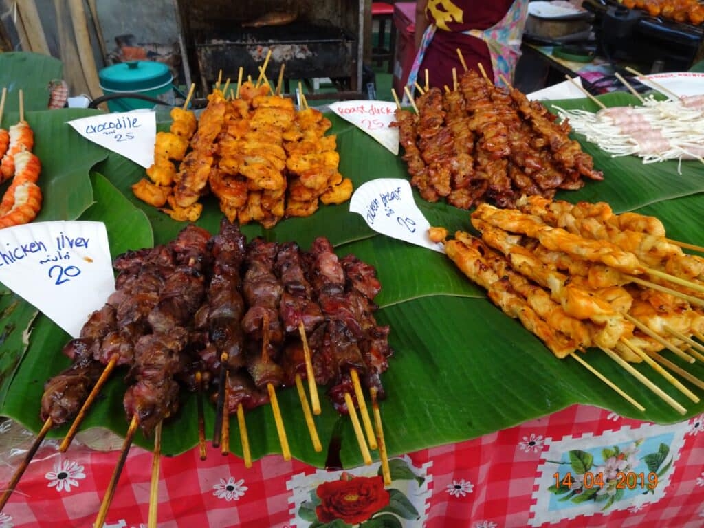 Kebabs on skewers made of wood on display for sale at a street market in Krabi.