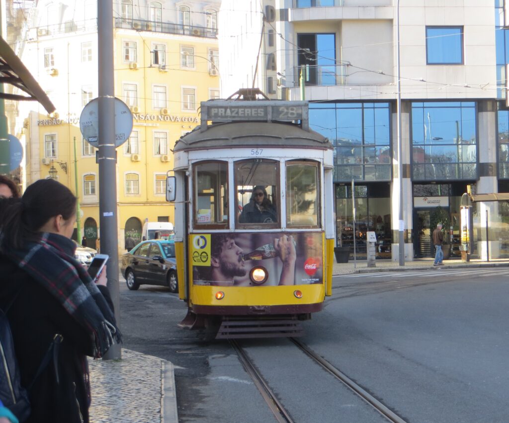 A yellow tram on the streets of central Lisbon.