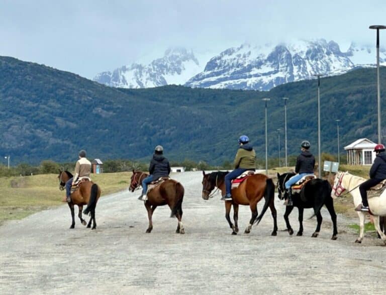 Horse back riders are crossing a road in Torres Del Paine Chile, a popular destination from January to March, when it is summer in the southern part of Chile.