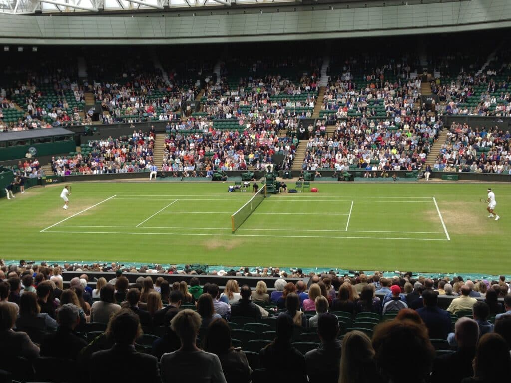Players at a tennis match with a full crowd in the famous Wimbledon Tennis Club, near London, UK.