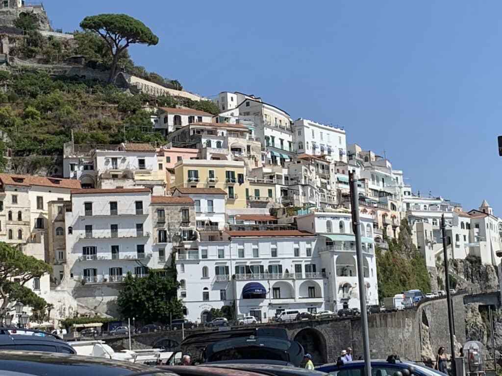 Amalfi Coast village with houses clinging to the steep hills around the ocean.