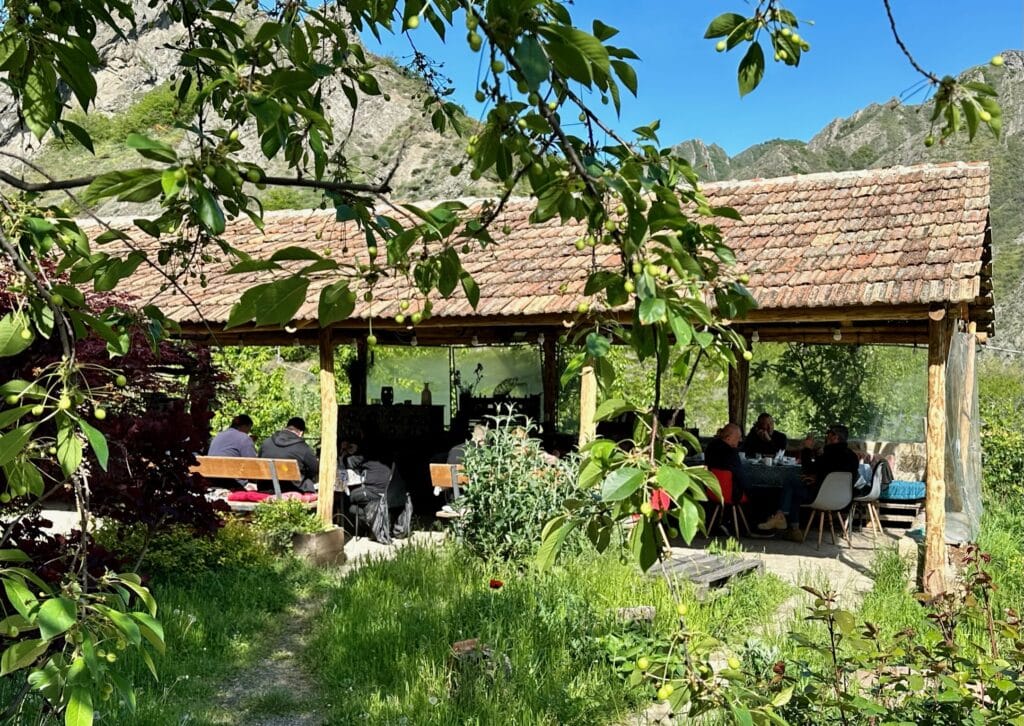 A covered open restaurant in Ateni Valley central Georgia. People are eating in the shade.
