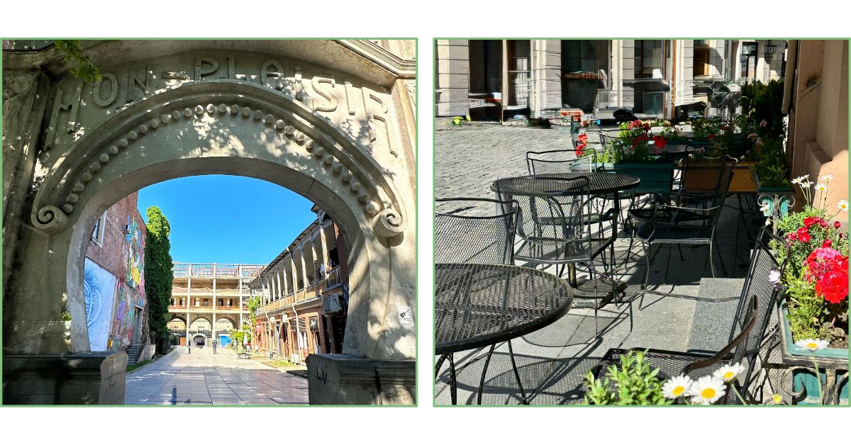 An archway into the Old Town of Kutaisi and street cafe chairs and tables, with summer flowers.