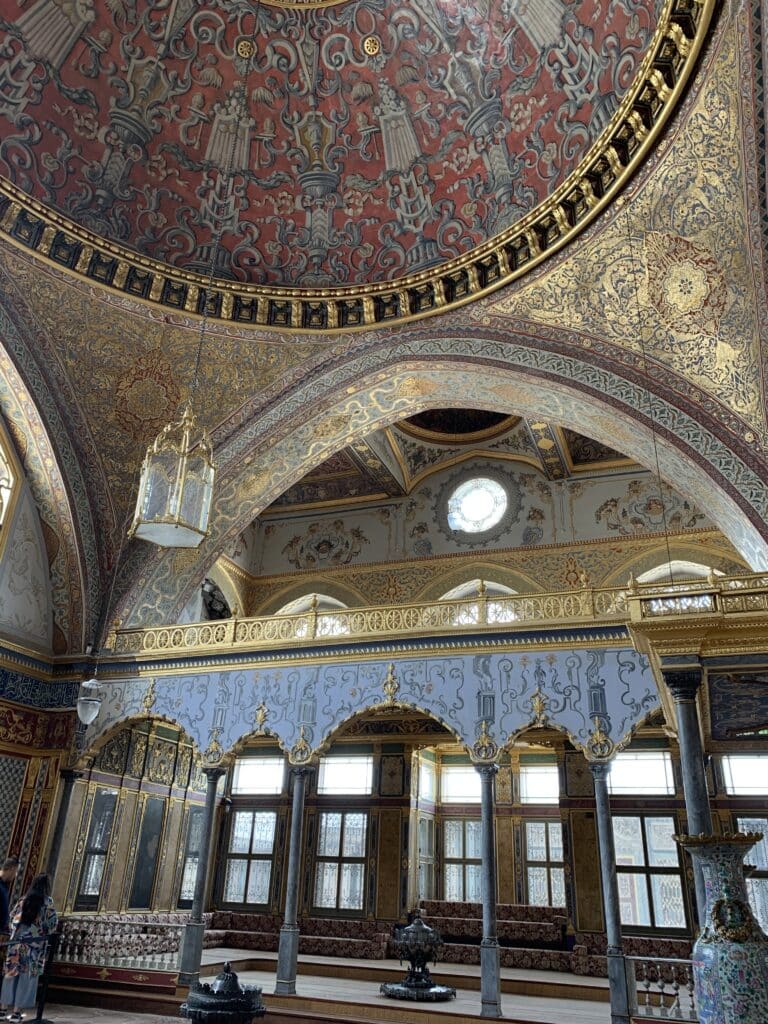 A ceiling highly decorated in red and gold inside Topaki Palace Istanbul.