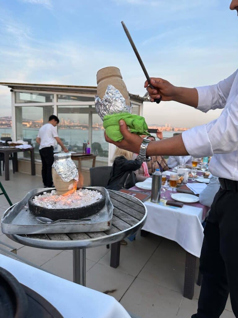 Clay pot being broken open at a roof top restaurant in Istanbul