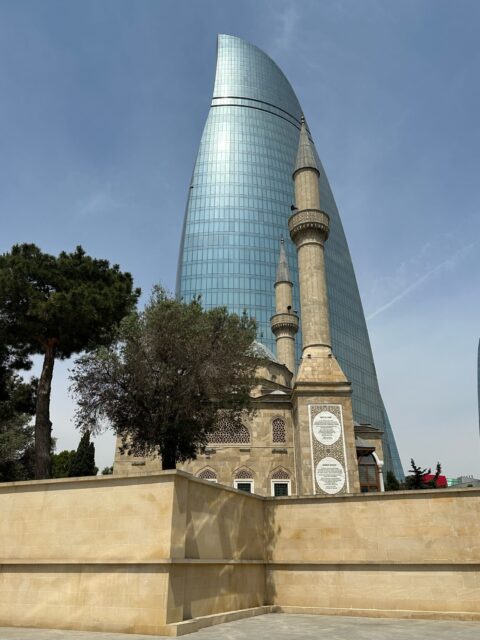 A mosque minaret and glass tower in Baku