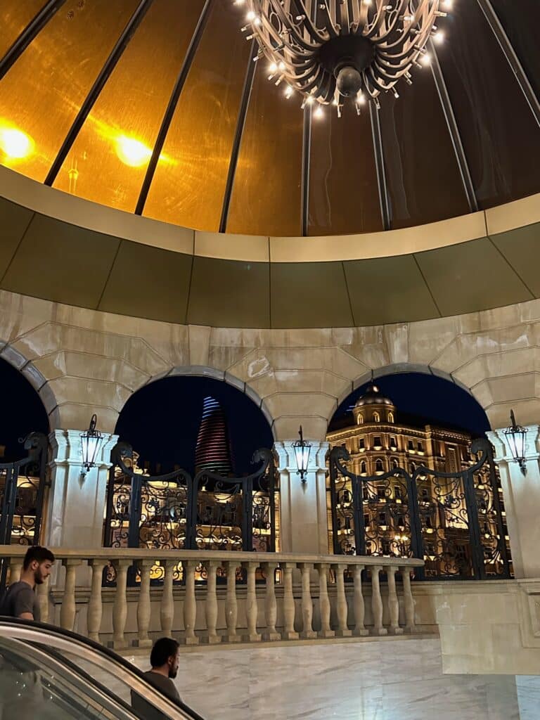 A station at night in the Baku Metro System has a large gold dome roof
