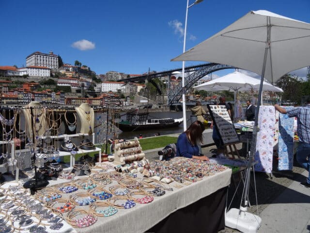 Market in Porto, Portugal where local artisans are selling jewelry and linens.