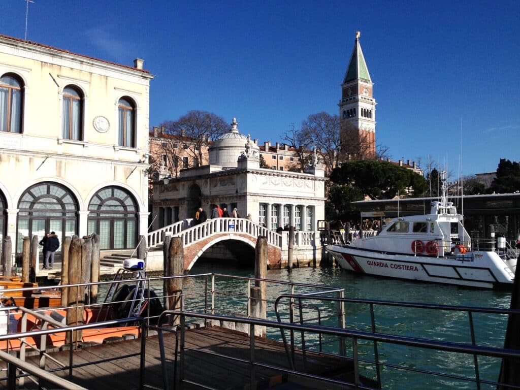 Typical scene in Venice with bridges, buildings on the canal, church spires, and a boat. Part of our Where to Go October to December destinations.