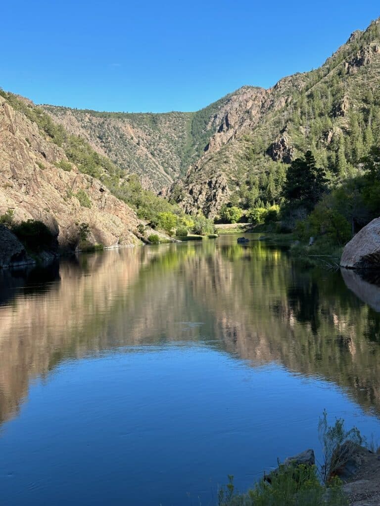 A high mountain lake in Colorado with reflection on the blue waters