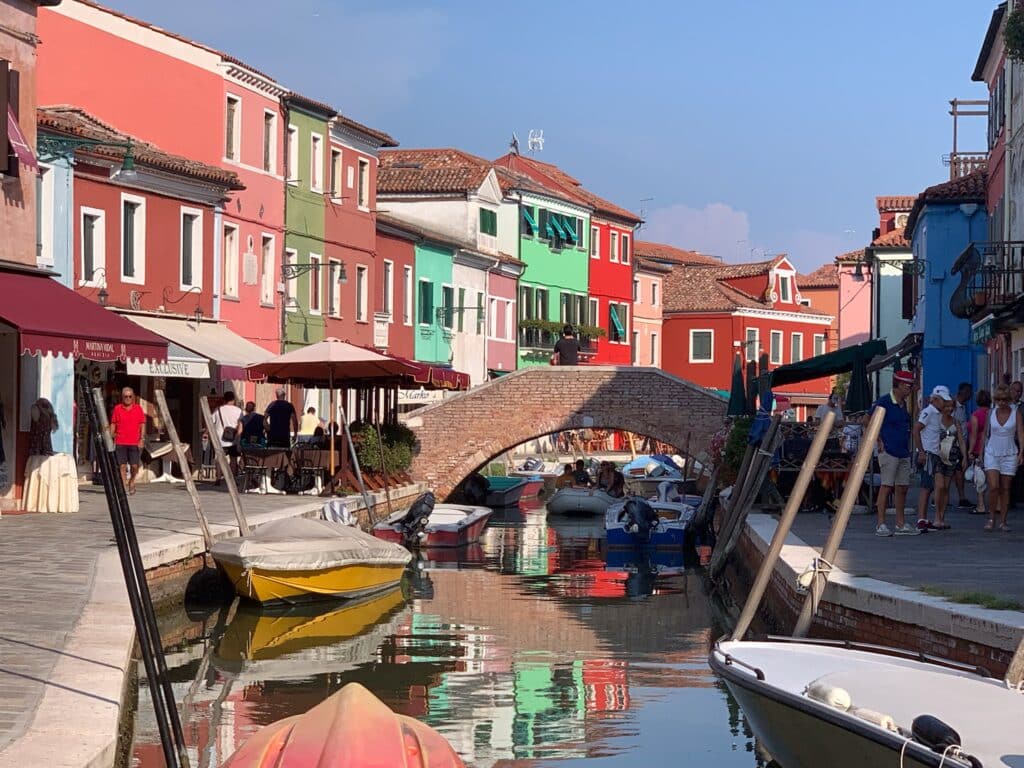 Murano is an island near Venice and has brightly painted houses with boats parked in the canal in front of them. A great destination for October to December.