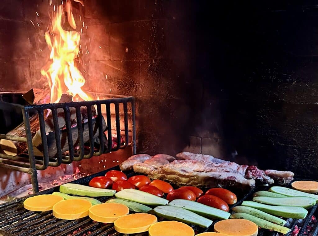 Traditional Asado in Mendoza. Meats and vegetables are on a wood fired grill.