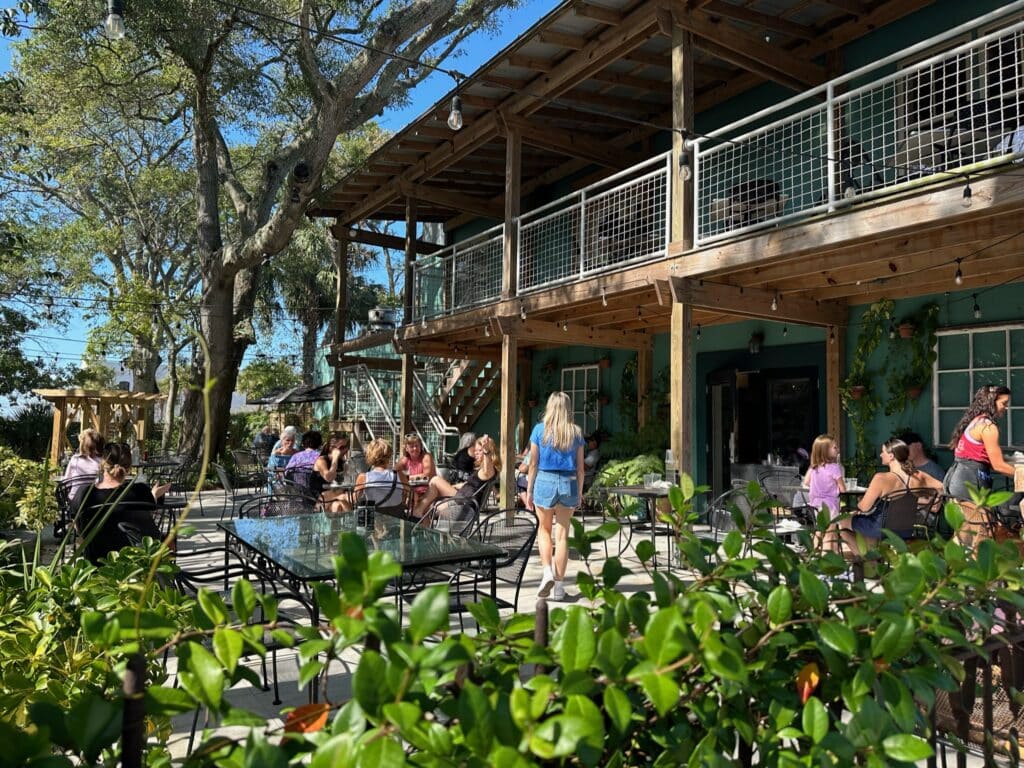 Where to Go October to December post features Amelia Island. Outdoor restaurants and cafes with flower filled gardens and balconies line the street.