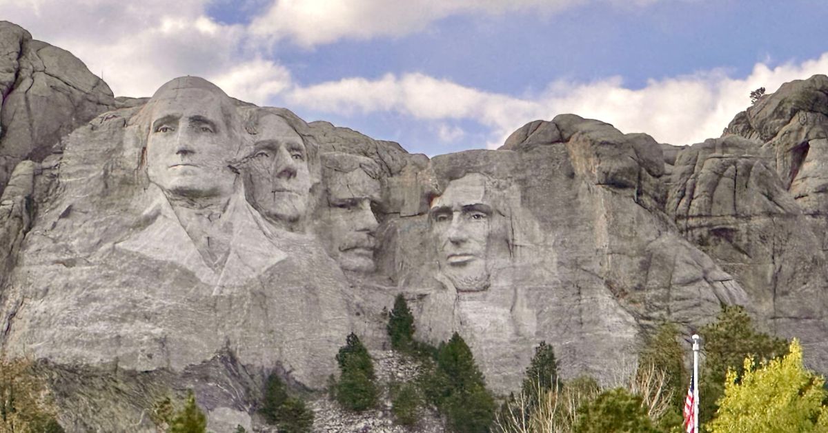 Faces of 4 USA Presidents carved on rocks of Mount Rushmore.