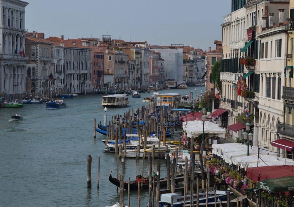 Venice Italy. Buildings and boats are on the right side of the canal and there are a couple of boats moving on the grand canal.
