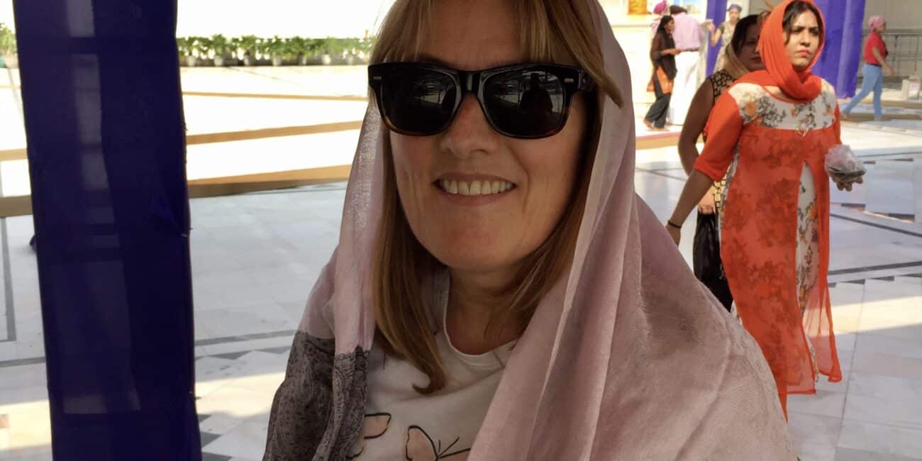 Travel Blogger with scarfed on head about to enter a template in India.