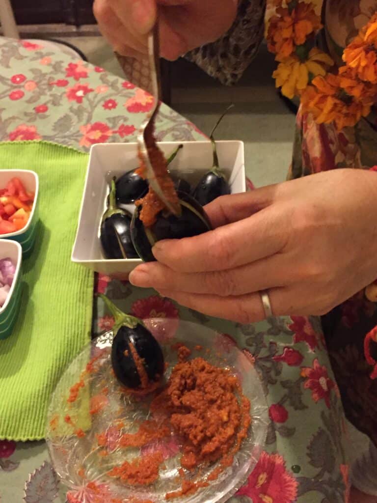Filling aubergine (egg plant) as part of a cooking class in Jaipur