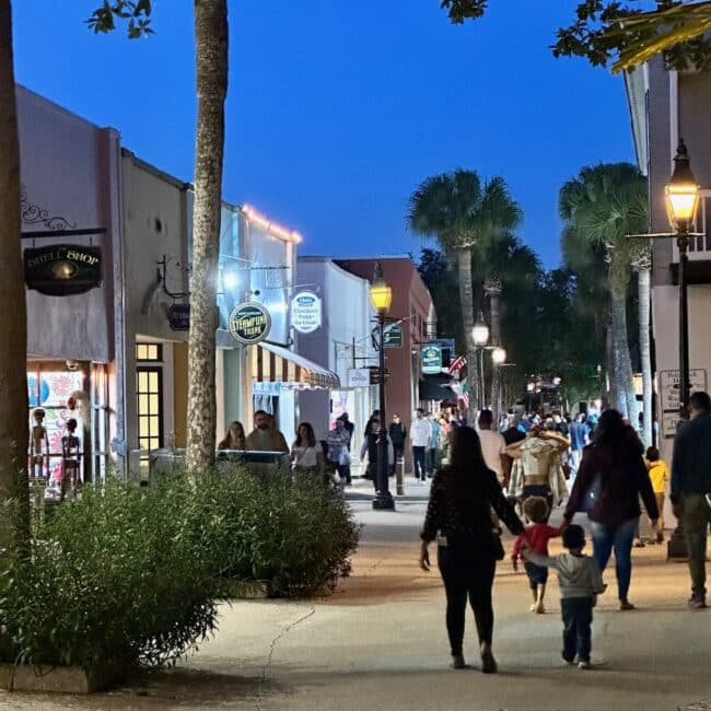 St Augustine down town is easy to explore on foot. This is a main street with visitors strolling down the shopping areas in the evening.