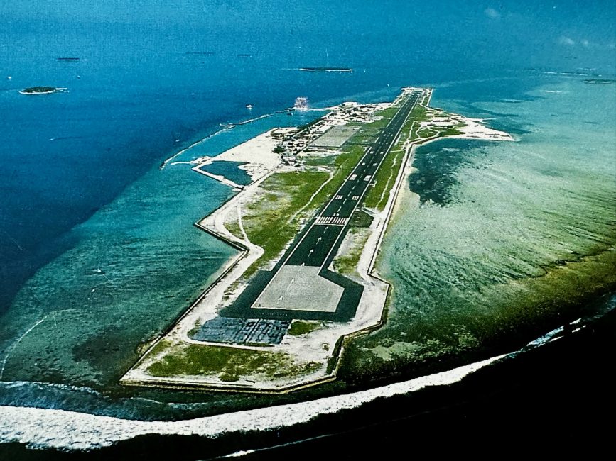 The airport landing strip in the Maldives shows a runway surrounded by water.