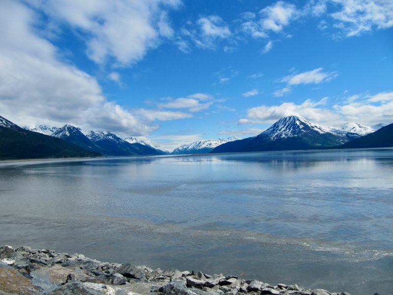 View of snow capped mountains with peaks reflecting in water in Alaska