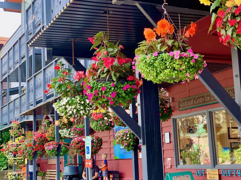 Flower baskets hanging from a building in Girdwood Alaska
