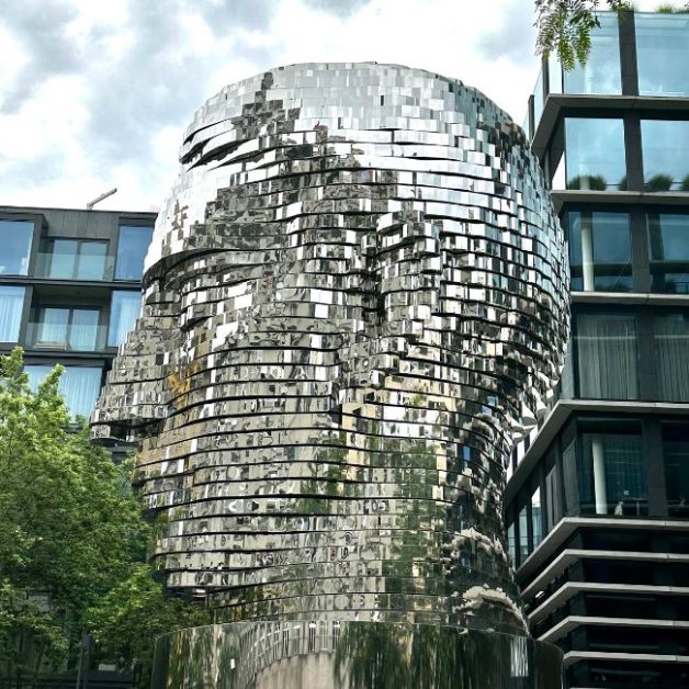 Artwork in the street of Prague is a rotating head of Fraz Kafa. Also a butterfly airplane attached to the outside of a building.