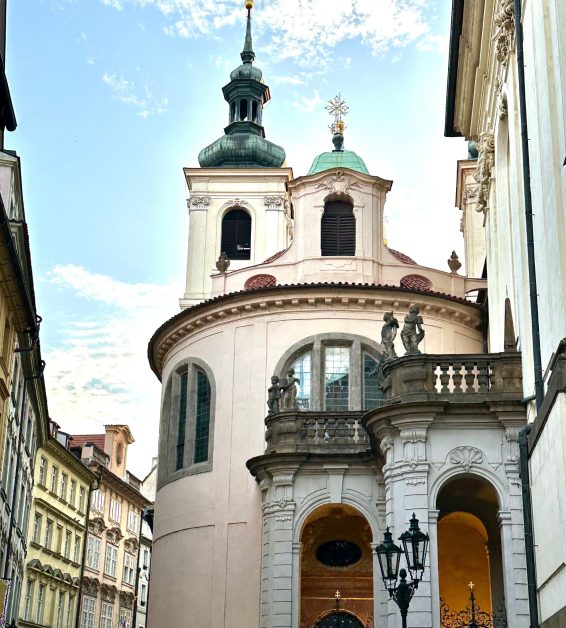 A round tower with dome roof sections is a church. It is located in Old Town Prague a popular place to visit.