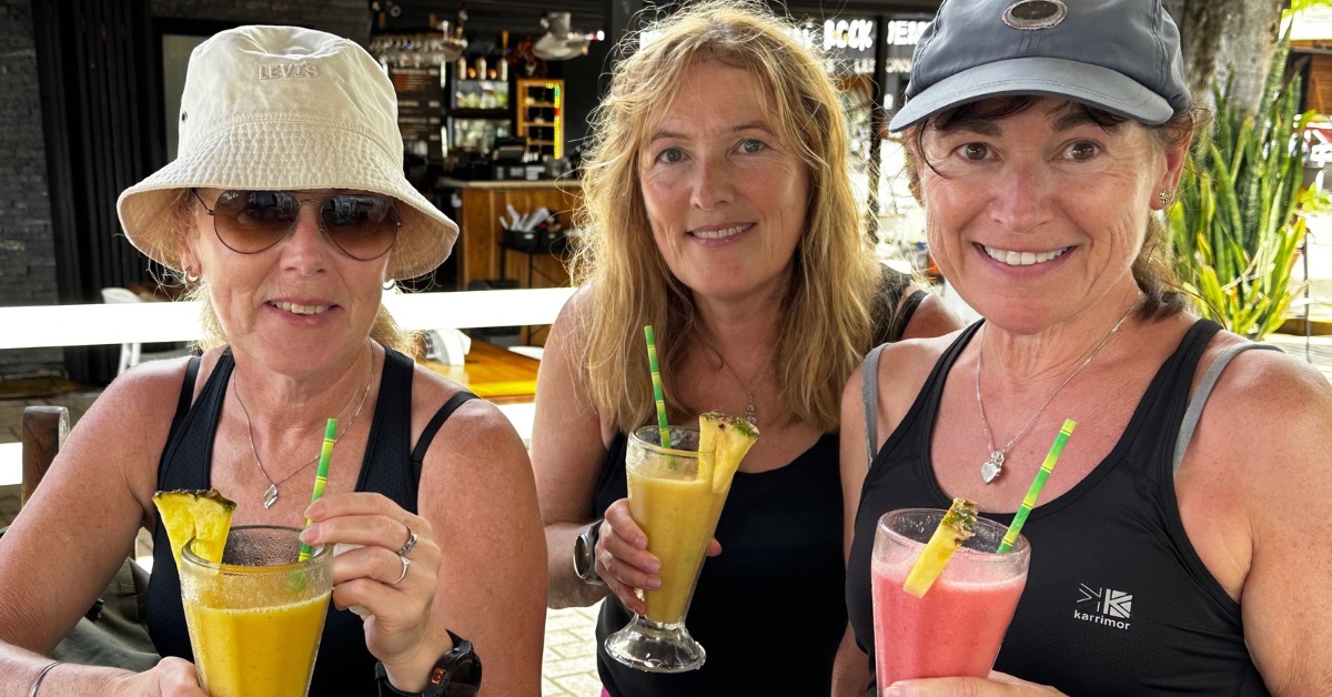 3 women enjoying fruit smoothies on Tamarindo Beach.
