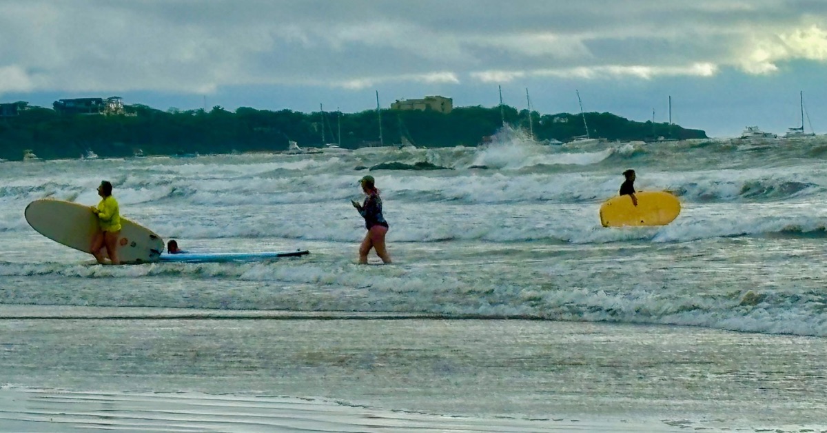 Surfers at Tamarindo Beach enjoying the waves.