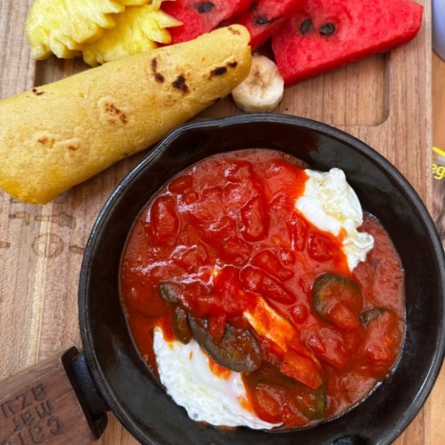 Breakfast plate with eggs and fresh fruits.