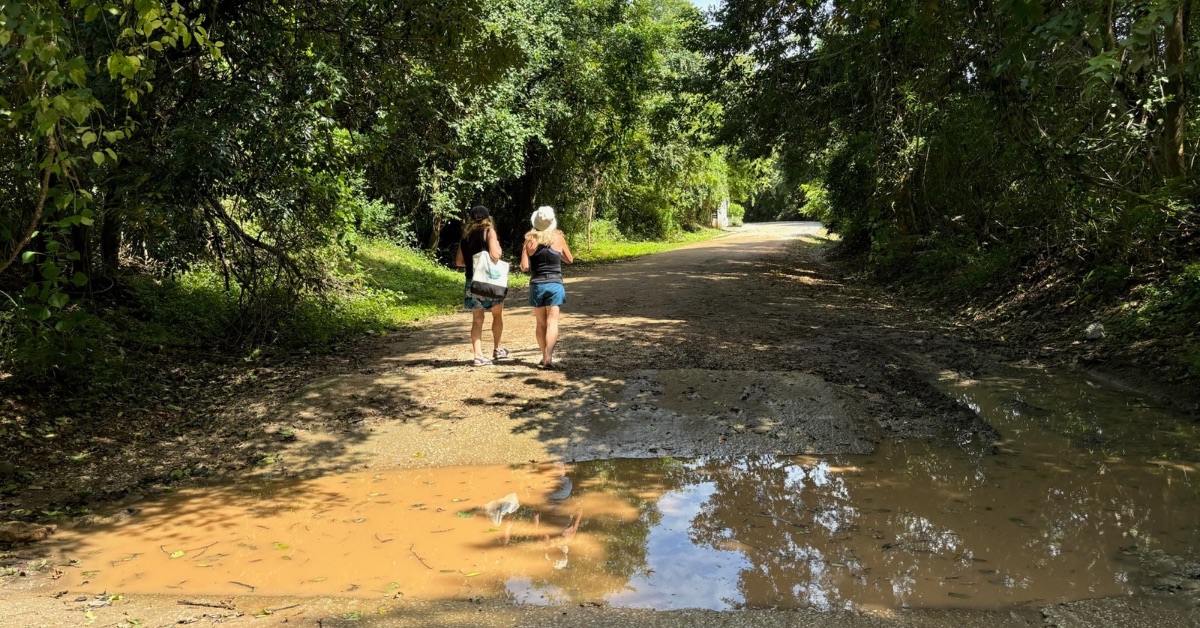 Two women walking on a dirt track on Playa Grande after a shower of rain.