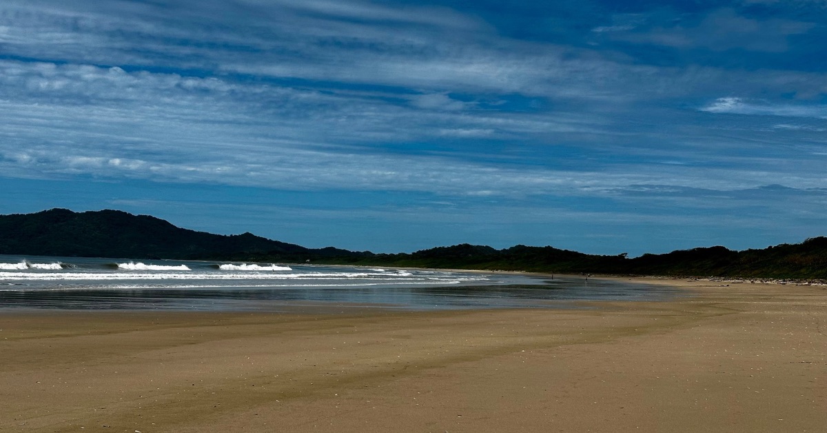 Playa Grande Beach early morning with wide expanse of sand and waves crashing onto the land.