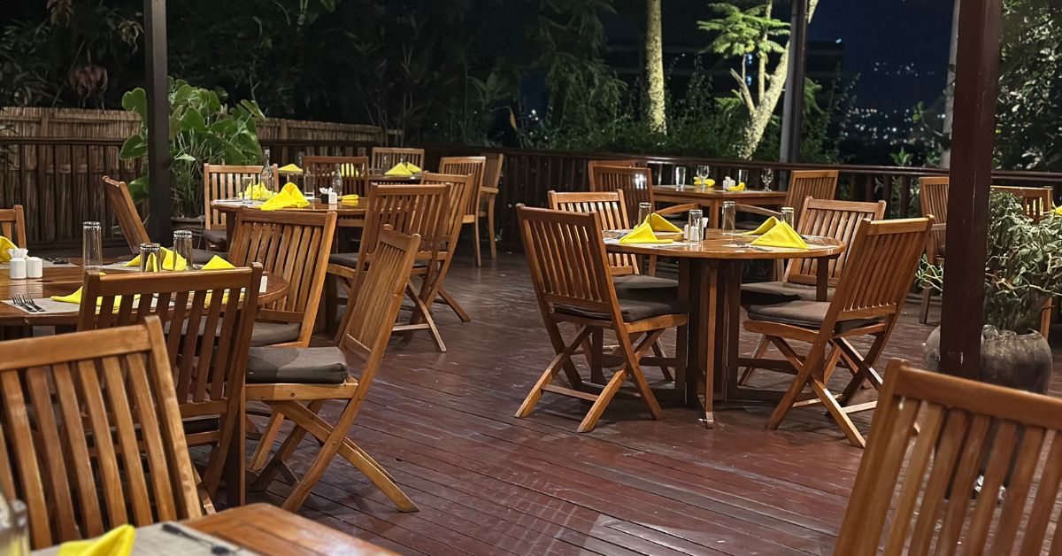 Outdoor patio restaurant with tables and chairs set for dinner guests.