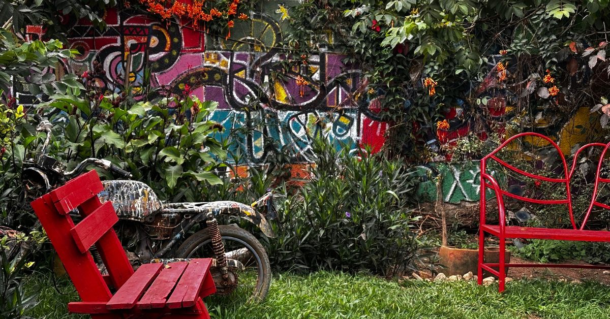A small garden with painted benches and spray painted motorcycle.