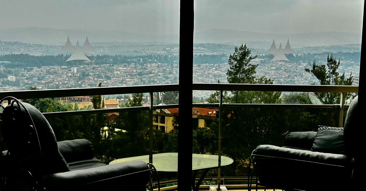 Two chairs on a balcony look over city views.
