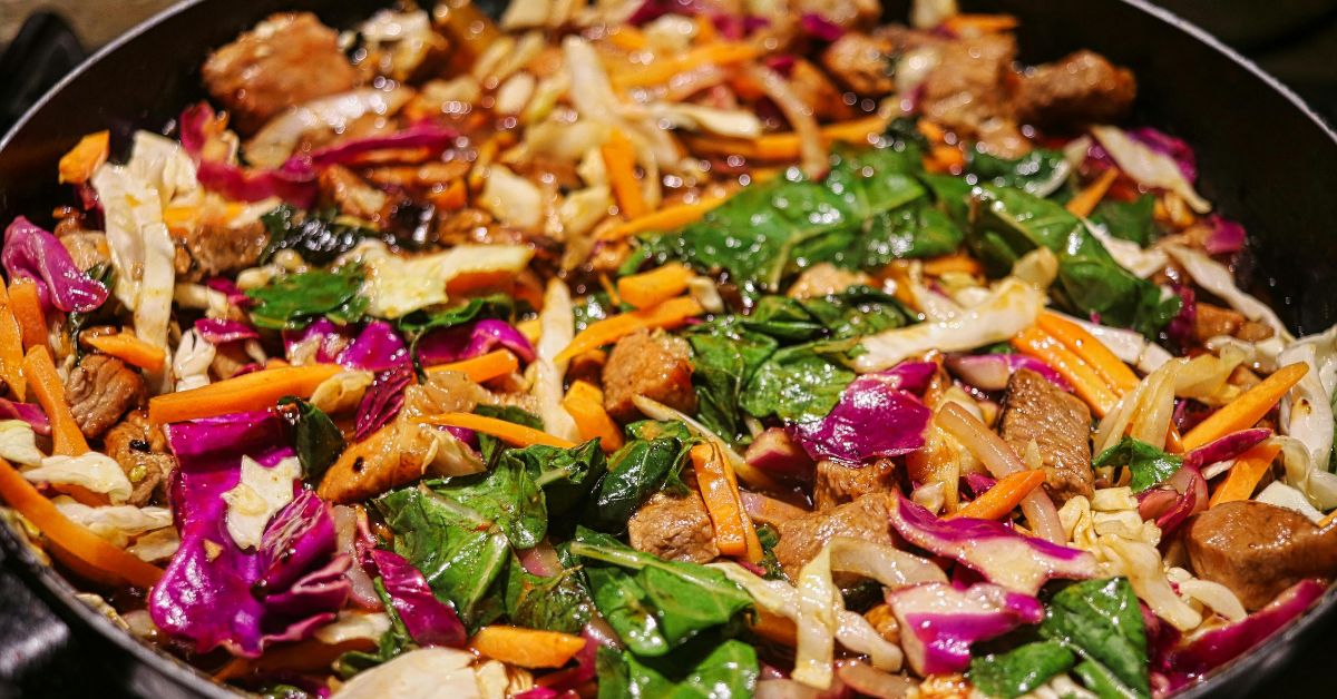 Multi colored Vegetables including carrots, spinach, potato and meat ready to eat.