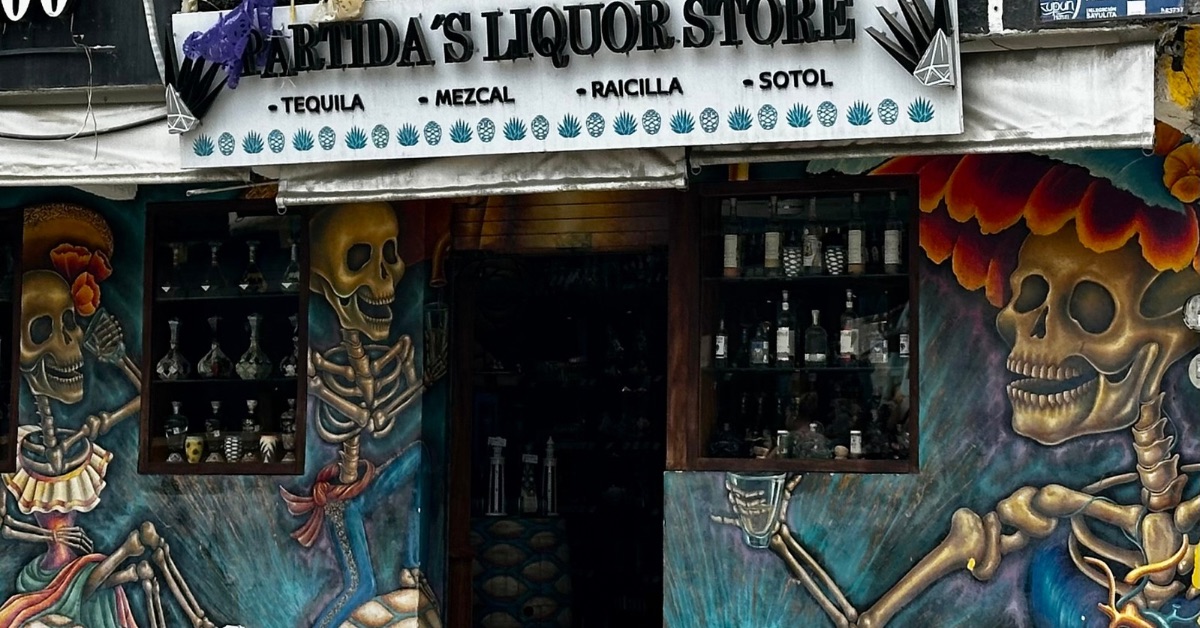 Tequila store with painted skeletons on the outside wall.