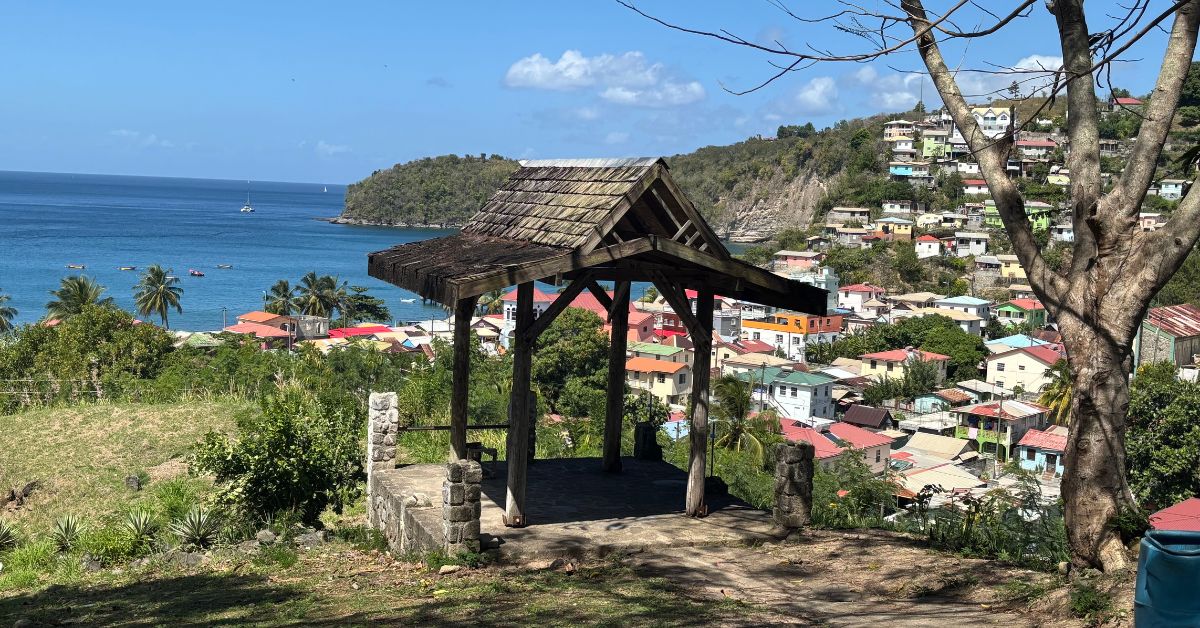 Wooden shelter viewpoint over town with houses perched on hillside and sea in the background