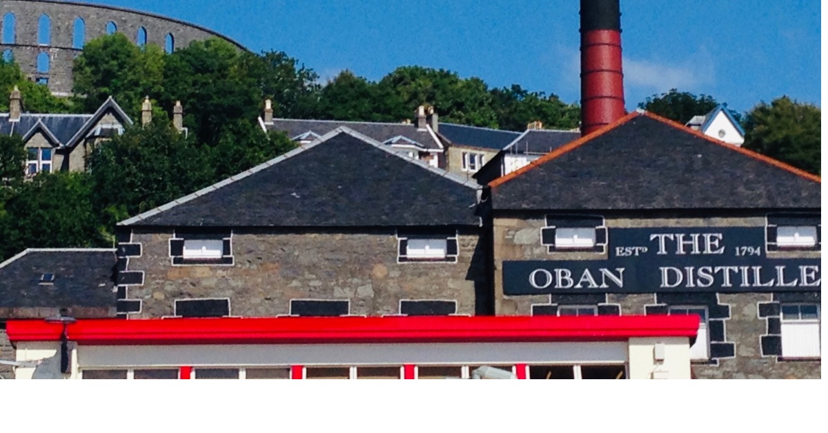 The Oban Distillery building in Oban with its smoke stack and tiled roof.