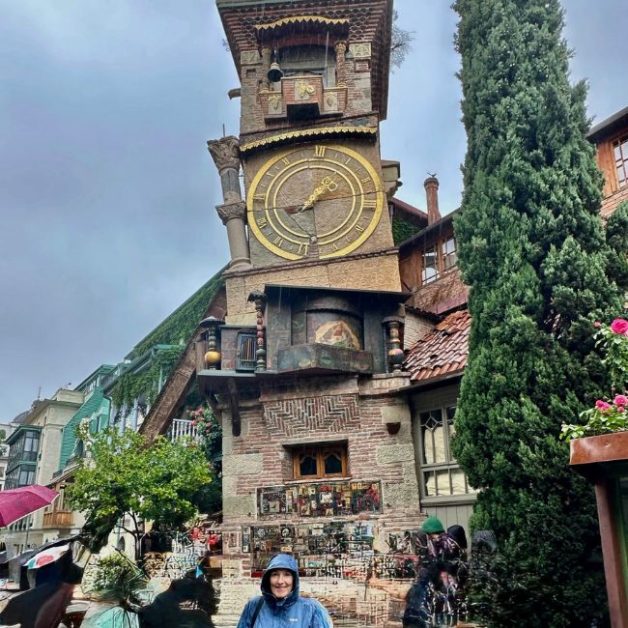 A clock tower with unique blocks of clocks and at the top a stage where a performance happens. twice daily.