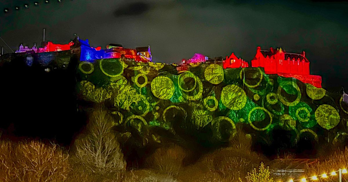 Lasers and lights creating a show on the walls of Edinburgh Castle with ever changing shapes and colors, against the night sky.