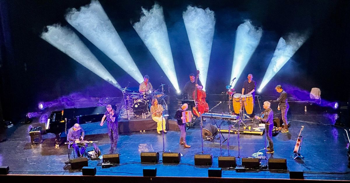 Musicians are playing a range of traditional Scottish instruments including fiddles on a stage in Edinburgh.